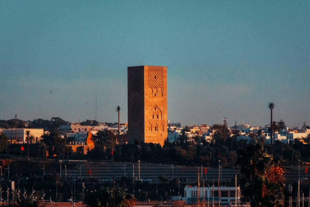 a mosque tower or minaret standing high in the middle of a city 