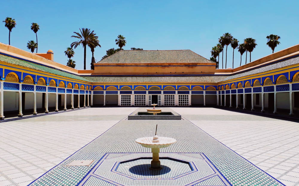 a large palace courtyard with two fountains in the middle